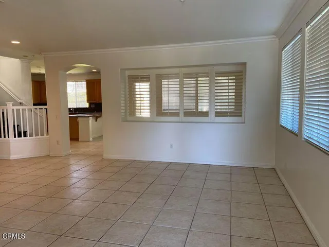 a view of an empty room with window and chandelier