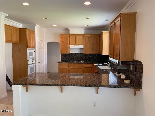 a kitchen with stainless steel appliances granite countertop a stove a sink and a refrigerator