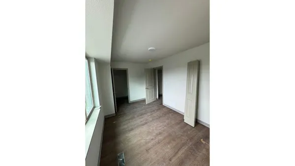 a view of a hallway with wooden floor