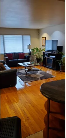 a kitchen with stainless steel appliances kitchen island granite countertop a table chairs and a refrigerator