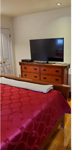 a living room with a bed and a flat screen tv