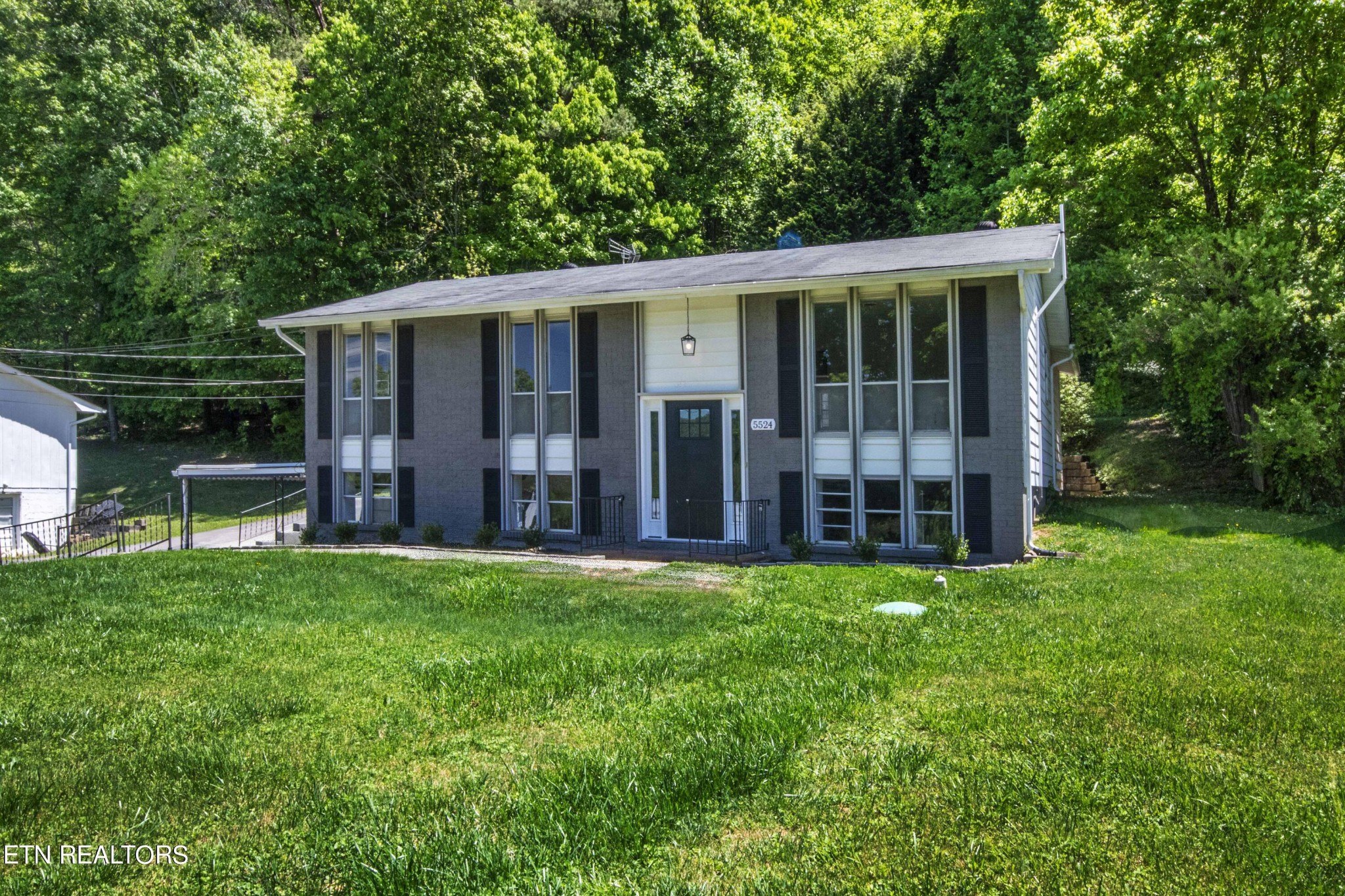 a view of a house with a yard and sitting area