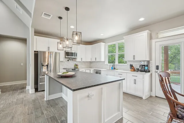 a kitchen with refrigerator cabinets and wooden floor