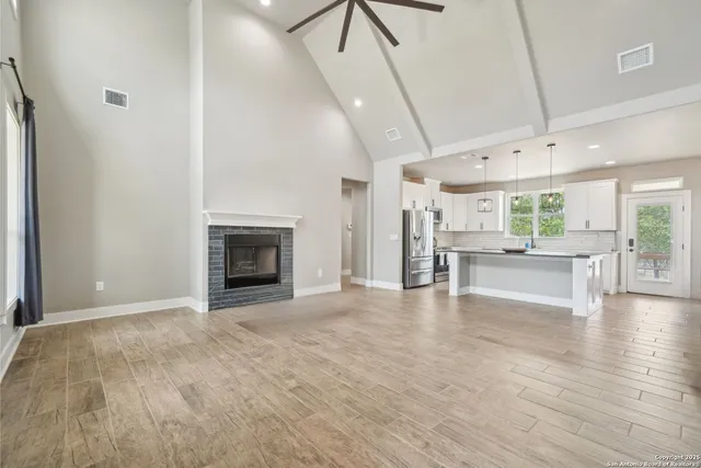 a view of an empty room with a fireplace and a window
