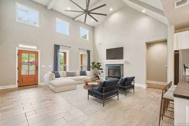 a living room with furniture a fireplace and a chandelier
