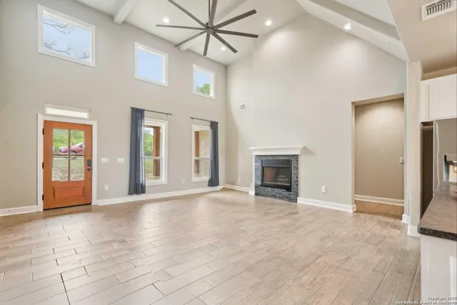 a view of an empty room with a fireplace and a window