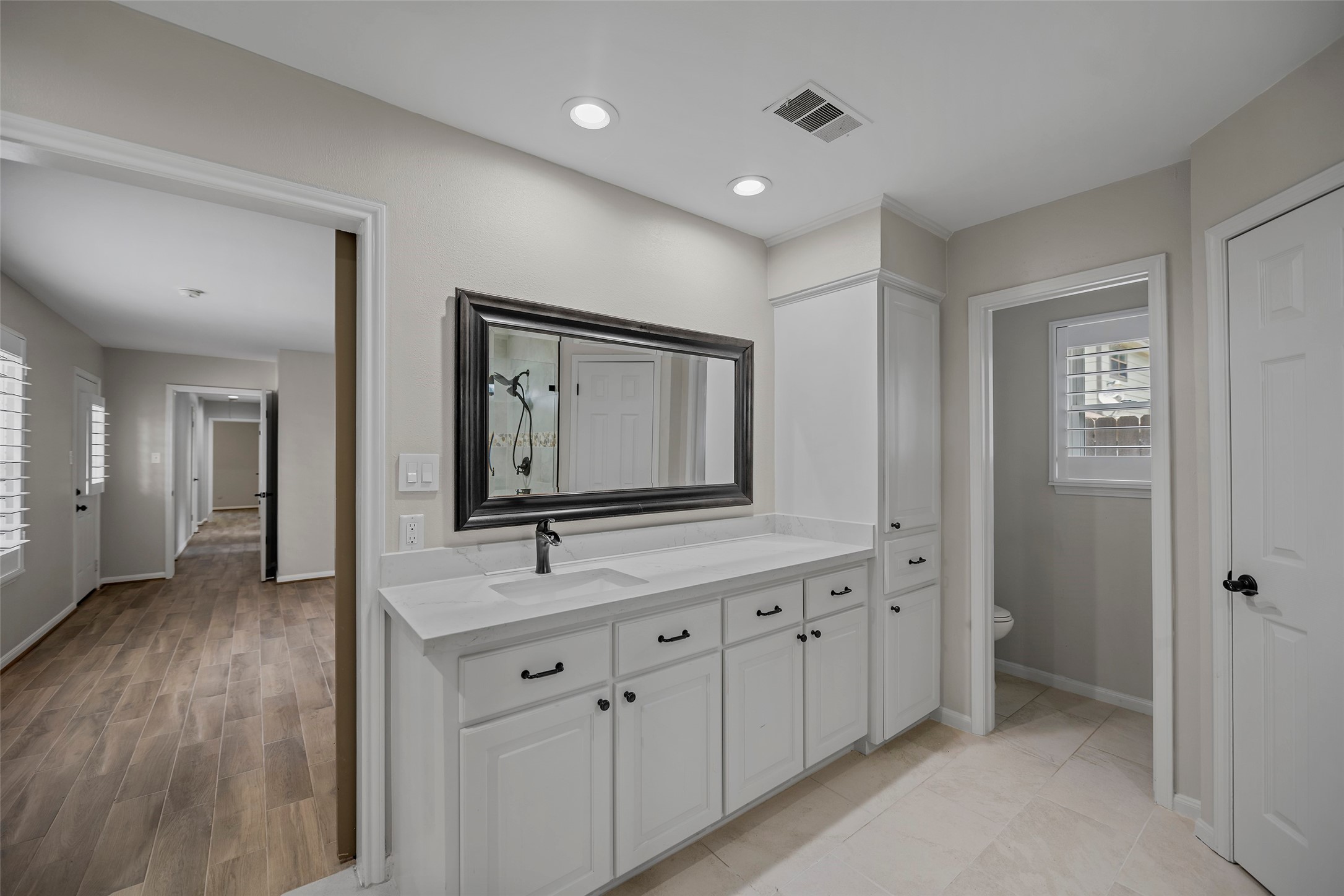6507 Allentown Drive Spring, TX 77389 - Photo 10 of 30 Primary bathroom vanity with elegant mirror, sink, lots of storage and a private toilet area with a door for added privacy.