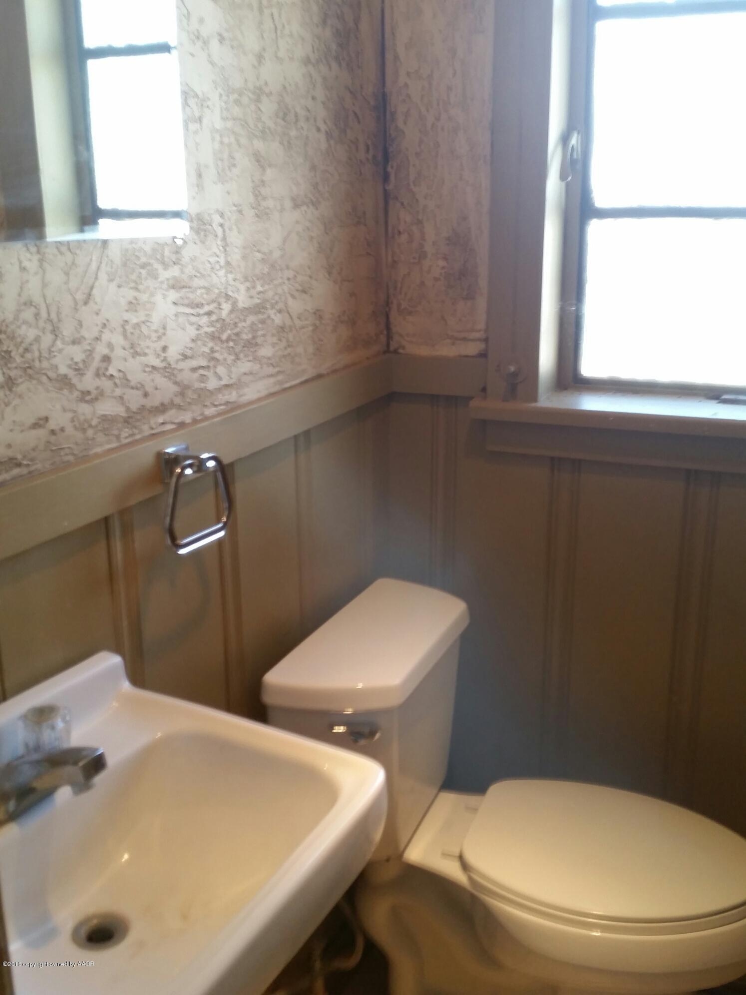 301 South Tyler Street Amarillo, TX 79101 - Photo 14 of 22 a white toilet sitting next to a bathroom sink