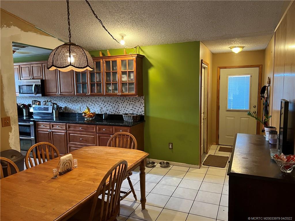 5140 Southeast Dell Street Stuart, FL 34997 - Photo 15 of 21 a kitchen with stainless steel appliances granite countertop a sink a stove and a wooden floors