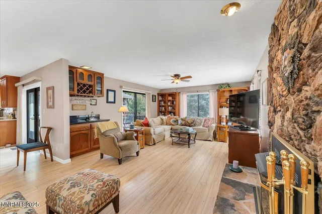 a living room with furniture large window and wooden floor