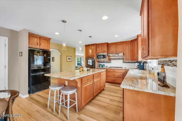a large kitchen with kitchen island granite countertop lots of counter top space and stainless steel appliances