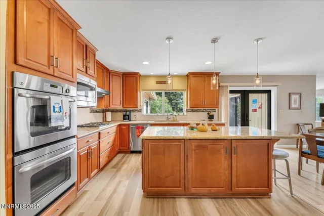 a kitchen with stainless steel appliances granite countertop a stove and cabinets