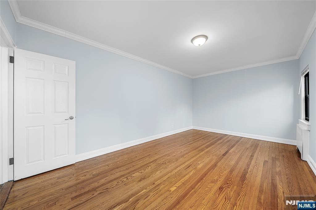 90 Tracey Place, Unit I1 Englewood, NJ 07631 - Photo 12 of 21 a view of empty room with wooden floor and fan