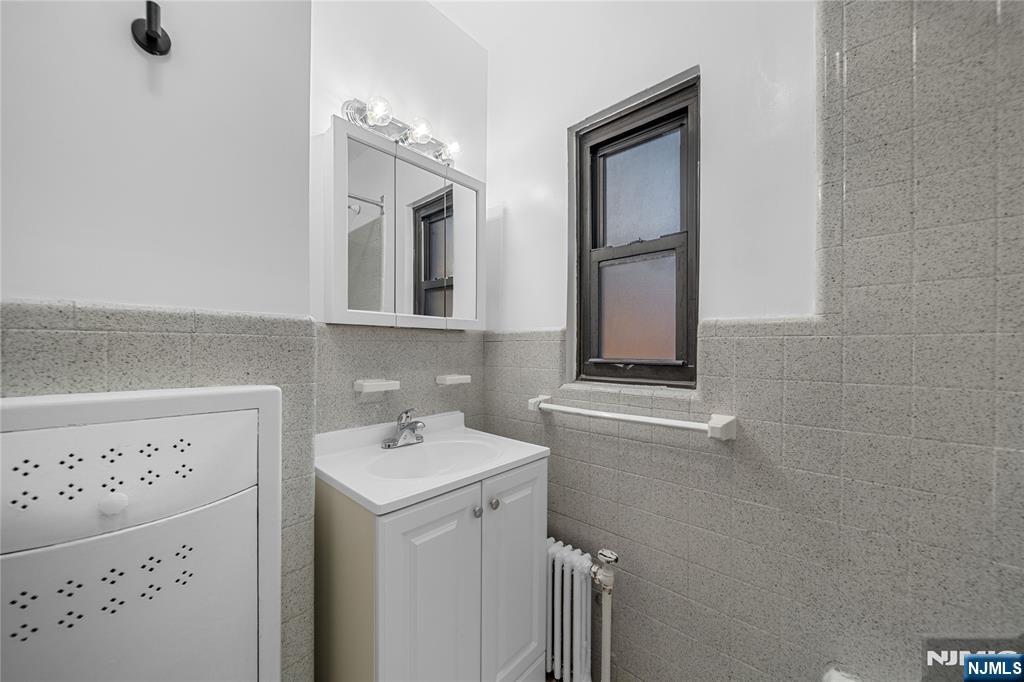 90 Tracey Place, Unit I1 Englewood, NJ 07631 - Photo 17 of 21 a bathroom with a sink a vanity and a mirror