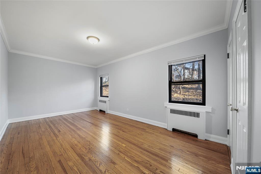 90 Tracey Place, Unit I1 Englewood, NJ 07631 - Photo 9 of 21 an empty room with wooden floor and windows