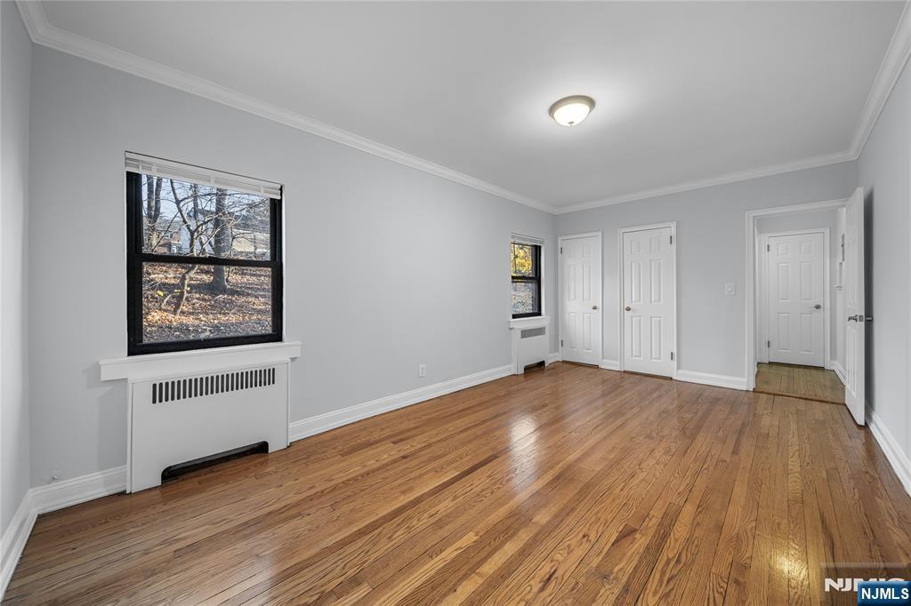 90 Tracey Place, Unit I1 Englewood, NJ 07631 - Photo 10 of 21 a view of an empty room with wooden floor and a window