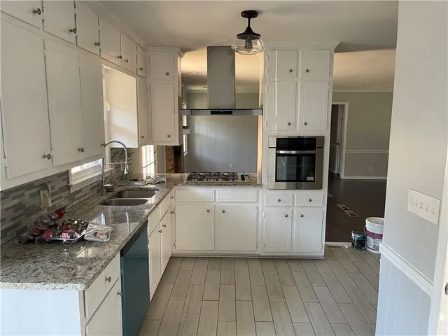 a kitchen with a sink stove and cabinets