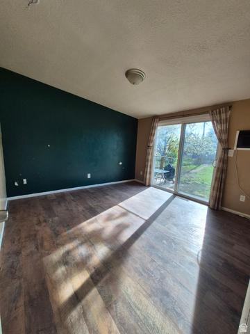 327 North 300 West Logan, UT 84321 - Photo 7 of 12 Empty room with a textured ceiling and dark wood-style floors
