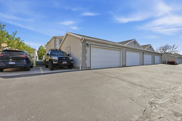 99 Penhurst Place Logan, UT 84341 - Photo 26 of 34 Multiple attached garages with white panel doors and stucco exteriors