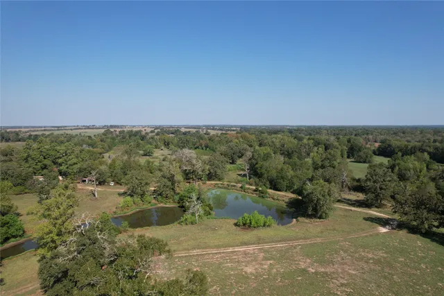 an aerial view of field with trees