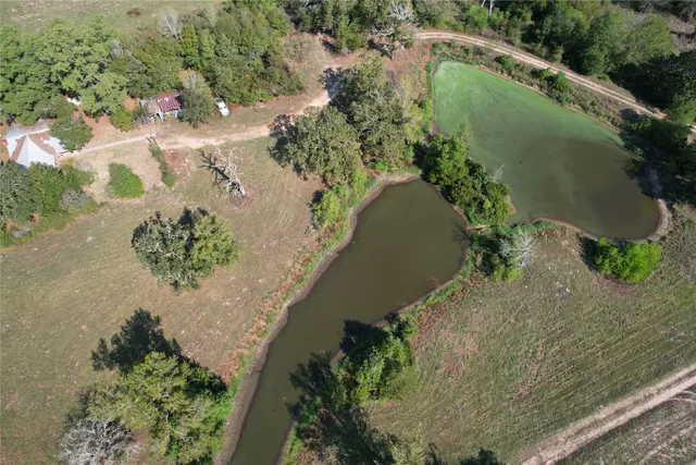 an aerial view of a house with a yard and lake view