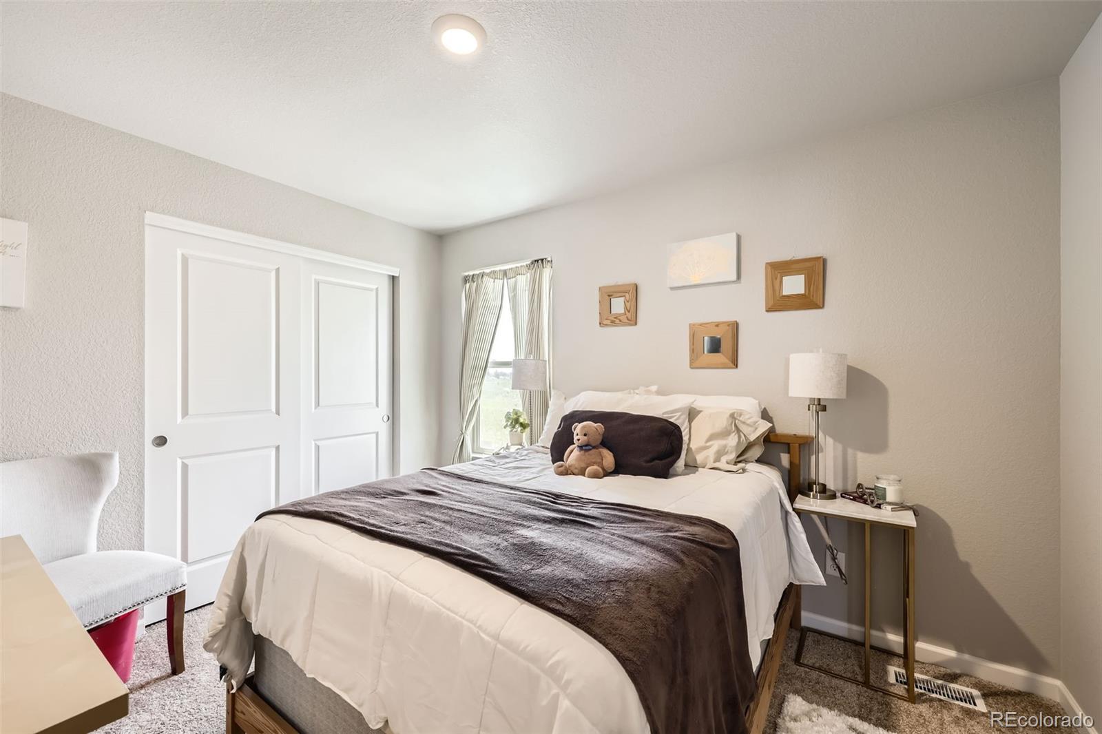 1063 Gianna Avenue Fort Lupton, CO 80621 - Photo 14 of 20 a bedroom with a bed and a window