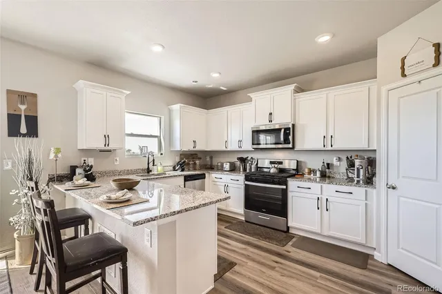 a kitchen with a sink stove top oven and refrigerator