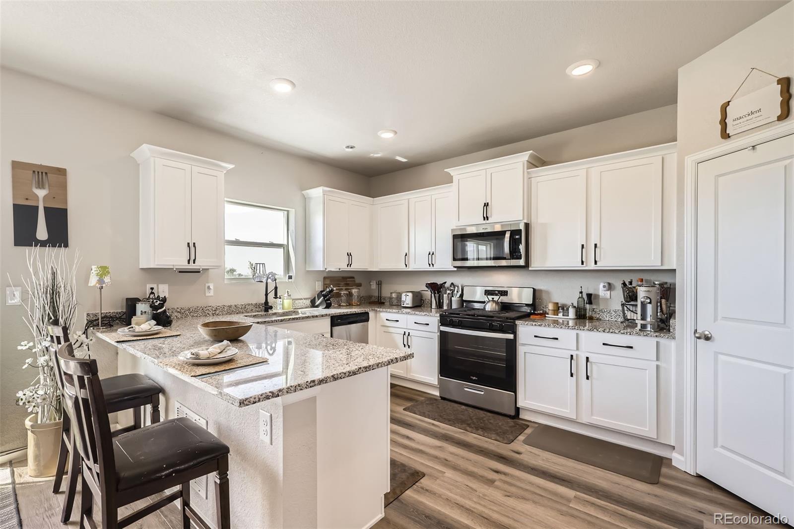 1063 Gianna Avenue Fort Lupton, CO 80621 - Photo 7 of 20 a kitchen with a sink stove top oven and refrigerator