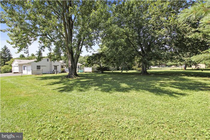 3227 Roderick Road Frederick, MD 21704 - Photo 3 of 23 a swimming pool that has lawn chairs and a dining table under an umbrella