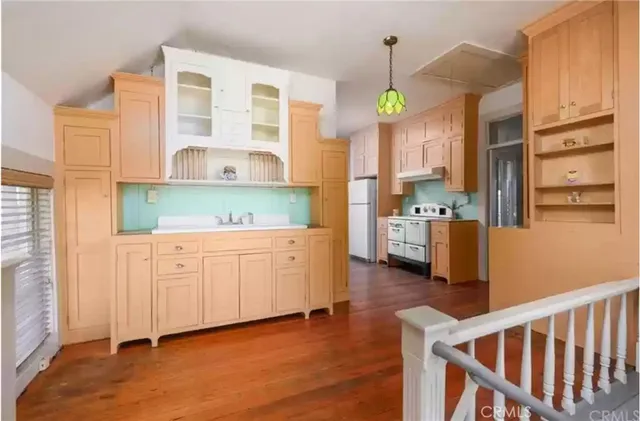 a kitchen with cabinets and wooden floors
