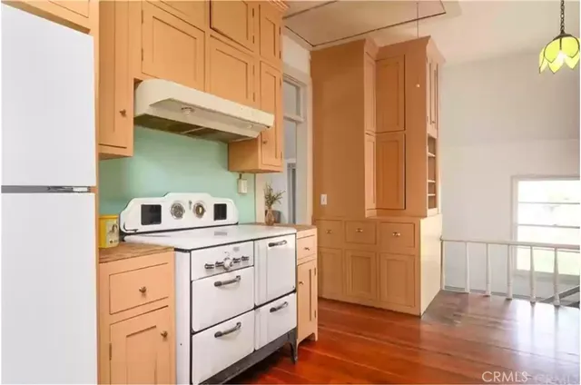 a kitchen with cabinets and wooden floor