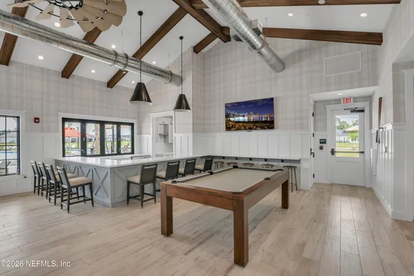 a living room with couches a dining table and chairs with wooden floor