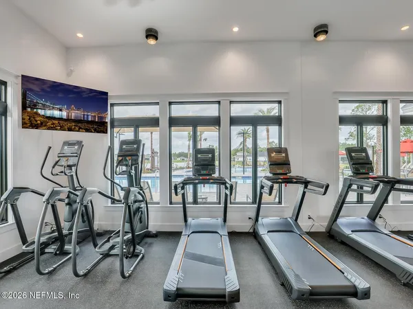 a room with gym equipment and large windows