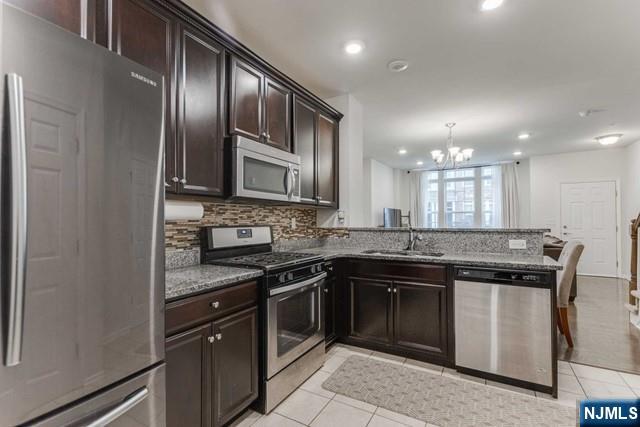 22 Veterans Drive Wood-Ridge, NJ 07075 - Photo 12 of 49 a kitchen with stainless steel appliances granite countertop a stove top oven a sink and dishwasher