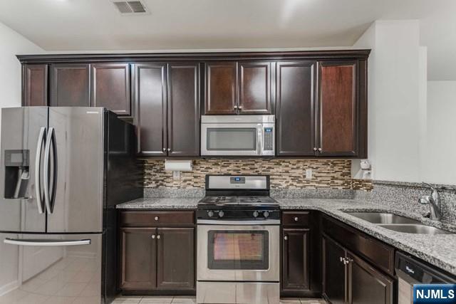 22 Veterans Drive Wood-Ridge, NJ 07075 - Photo 16 of 49 a kitchen with granite countertop a refrigerator stove and sink