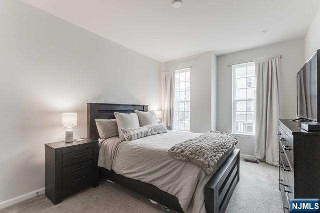 22 Veterans Drive Wood-Ridge, NJ 07075 - Photo 21 of 49 a bedroom with a bed flat screen tv and a large window