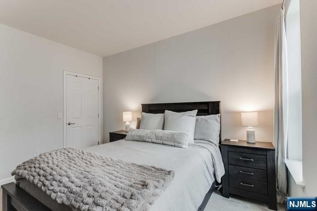 22 Veterans Drive Wood-Ridge, NJ 07075 - Photo 24 of 49 a bedroom with a bed and a night stand
