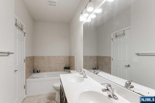 22 Veterans Drive Wood-Ridge, NJ 07075 - Photo 31 of 49 a bathroom with a tub sink and mirror