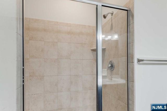 22 Veterans Drive Wood-Ridge, NJ 07075 - Photo 32 of 49 a bathroom with a glass shower door and a mirror