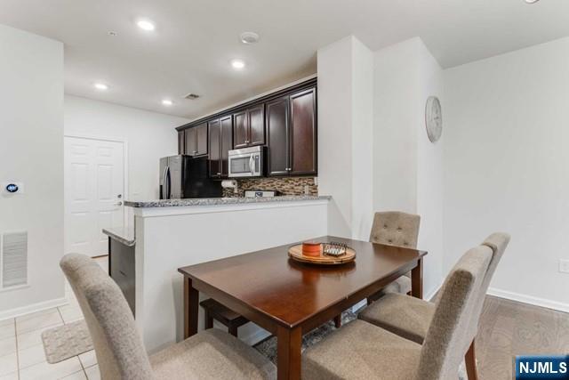 22 Veterans Drive Wood-Ridge, NJ 07075 - Photo 10 of 49 a kitchen with kitchen island a dining table and chairs