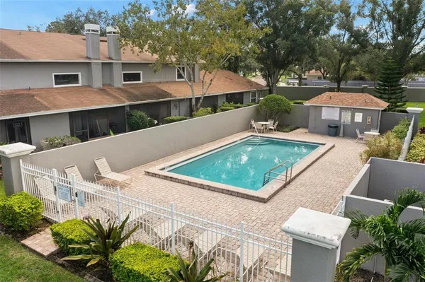 a view of a house with pool and chairs