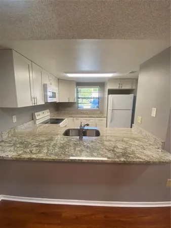 a view of a room with wooden floor and cabinets