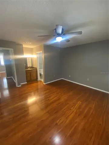 a view of empty room with wooden floor