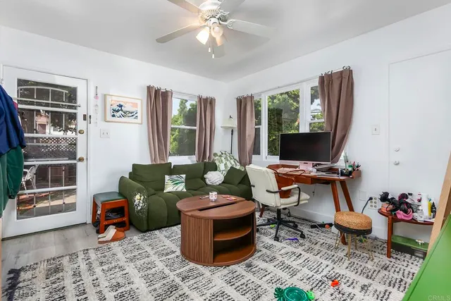 a living room with furniture a flat screen tv and a floor to ceiling window