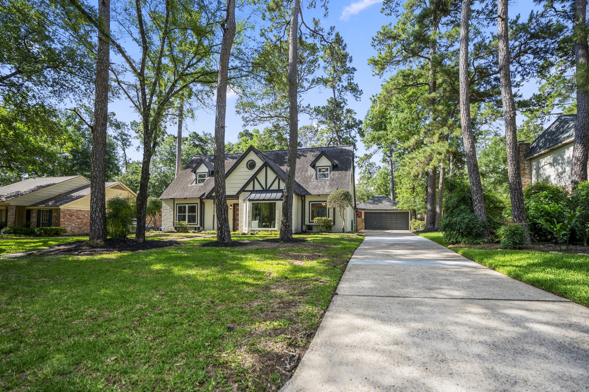6303 Larkmount Drive Spring, TX 77389 - Photo 2 of 50 Stepping back for a moment, the full setting comes into view — towering trees, refreshed exterior finishes, and a long driveway leading you home in Northampton. The blend of mature character and recent updates gives this property an inviting feel before you ever make it to the front door.