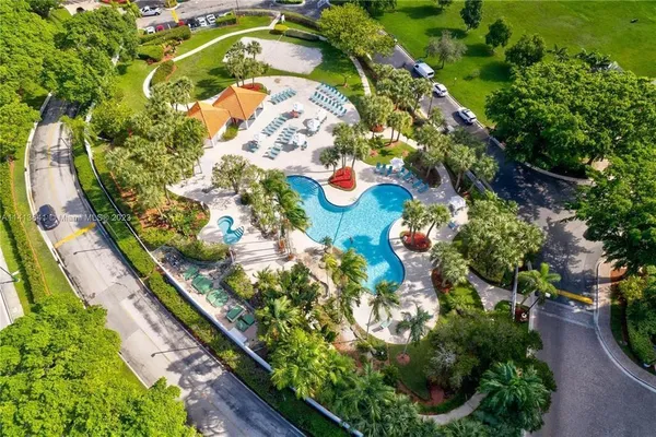 a view of swimming pool with lawn chairs and plants