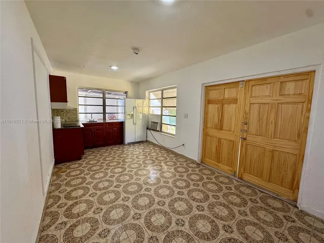 a large bedroom with a bed and wooden floor