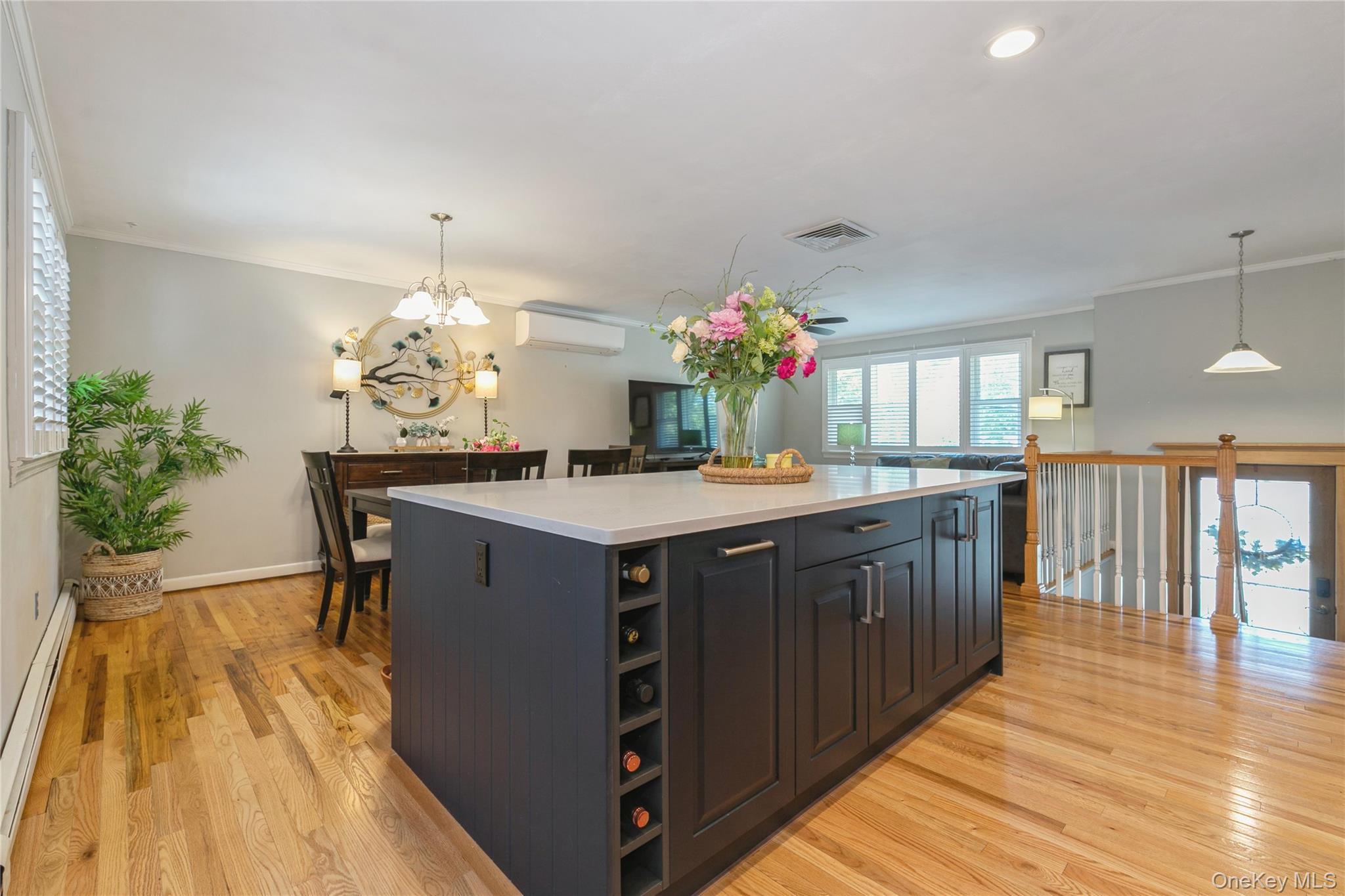 115 Clarendon Road Ronkonkoma, NY 11779 - Photo 14 of 45 Kitchen island featuring dark cabinetry, integrated wine storage, and a light-toned countertop