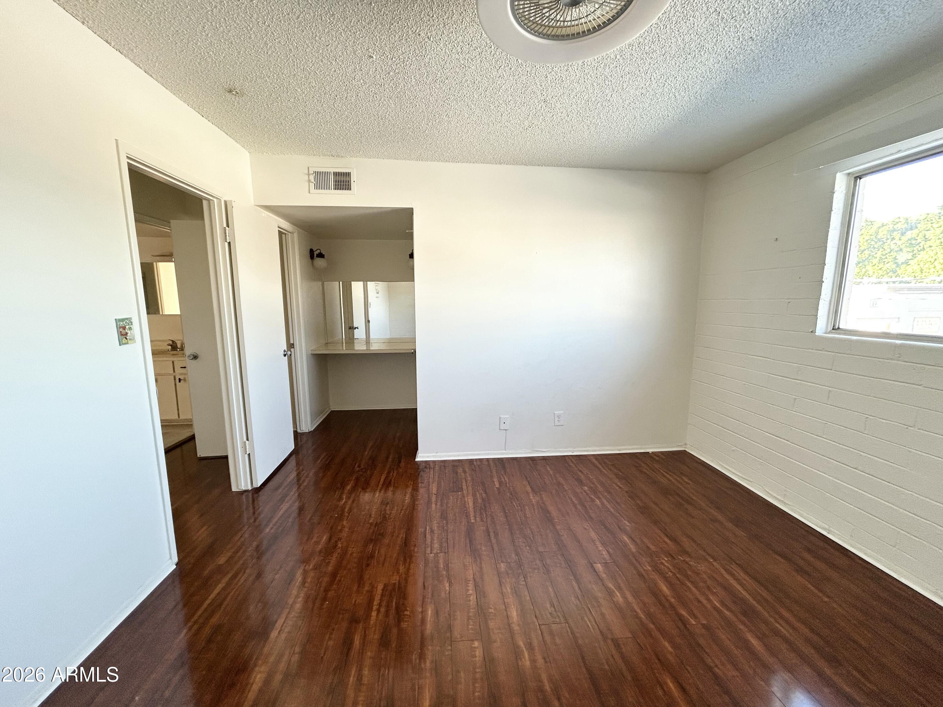 6565 North 19th Avenue, Unit 27 Phoenix, AZ 85015 - Photo 11 of 17 an empty room with wooden floor and windows
