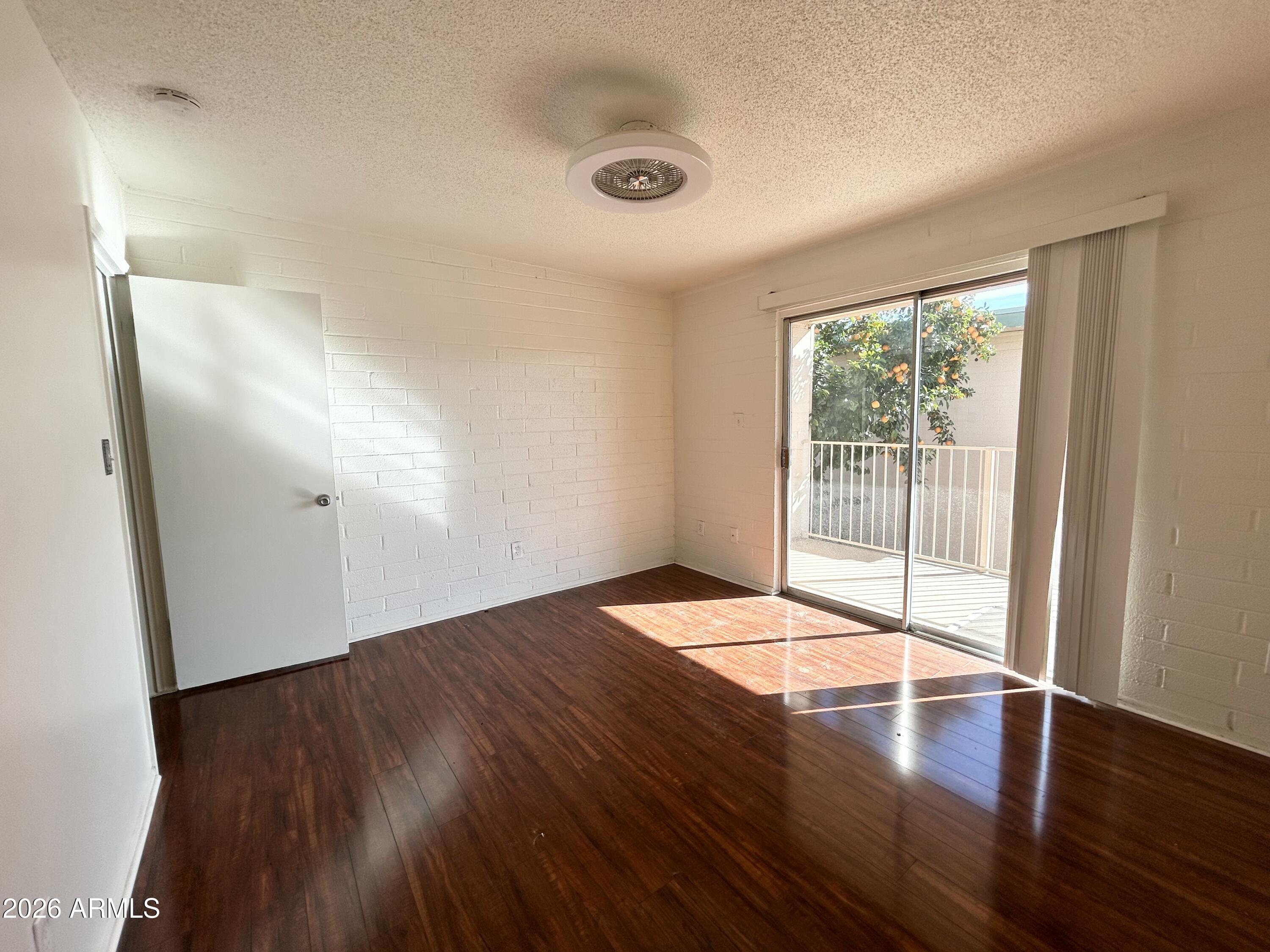 6565 North 19th Avenue, Unit 27 Phoenix, AZ 85015 - Photo 6 of 17 an empty room with wooden floor and windows